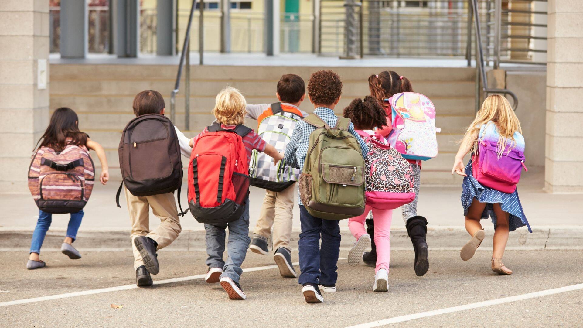 Bimbi che corrono verso la scuola